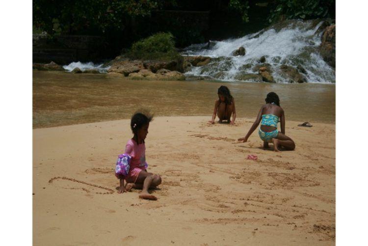 Visit Jamaica: Land I Love. Children frolicking on James Bond Beach. 