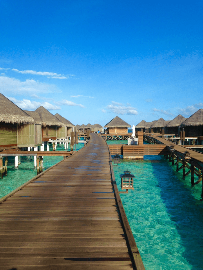 wooden walkway pier to water villas