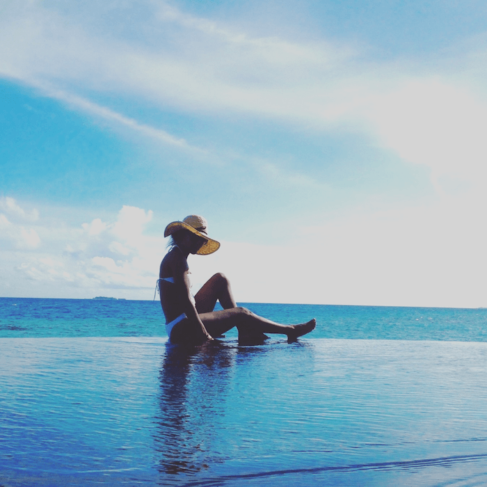 woman at edge of infinity pool overlooking ocean