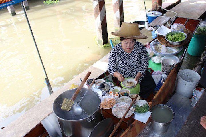 Thai woman cooking noodles for sale