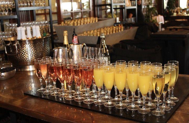 A tray of glasses filled with wine and mimosas