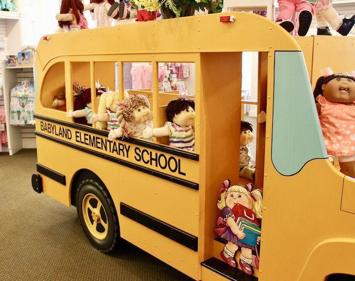 Cabbage Patch Kids riding a wooden school bus