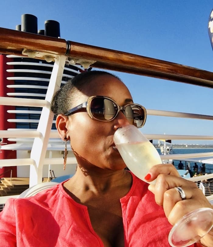 woman drinking champagne on the deck of a cruise ship