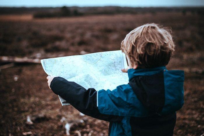 young male child holding map