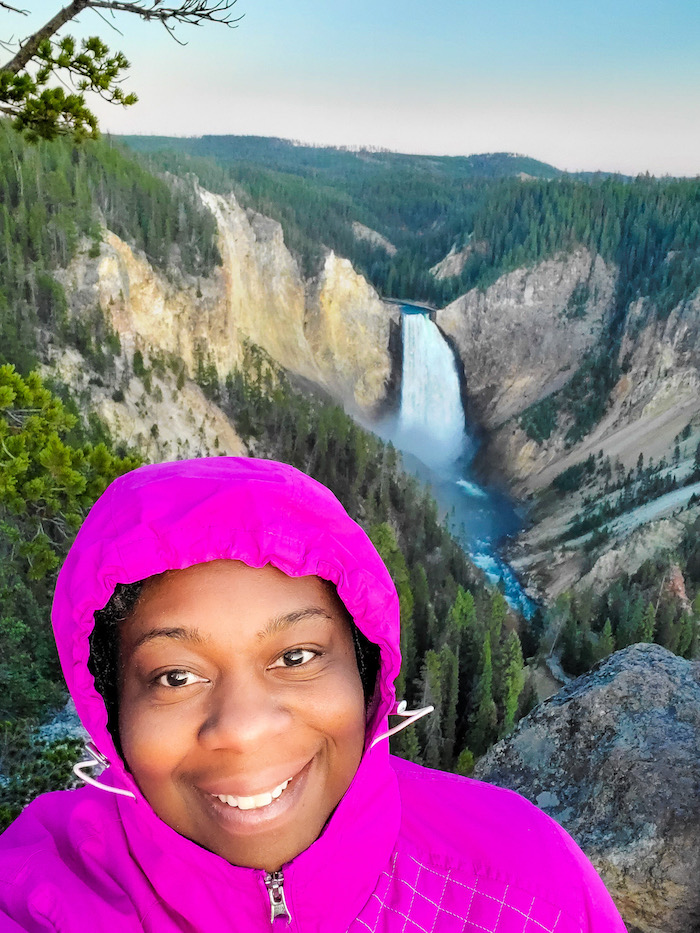 Lauren standing overlooking a waterfall in Yellowstone National park