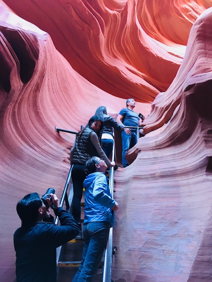 people climbing up a ladder in Lower Antelope Canyon