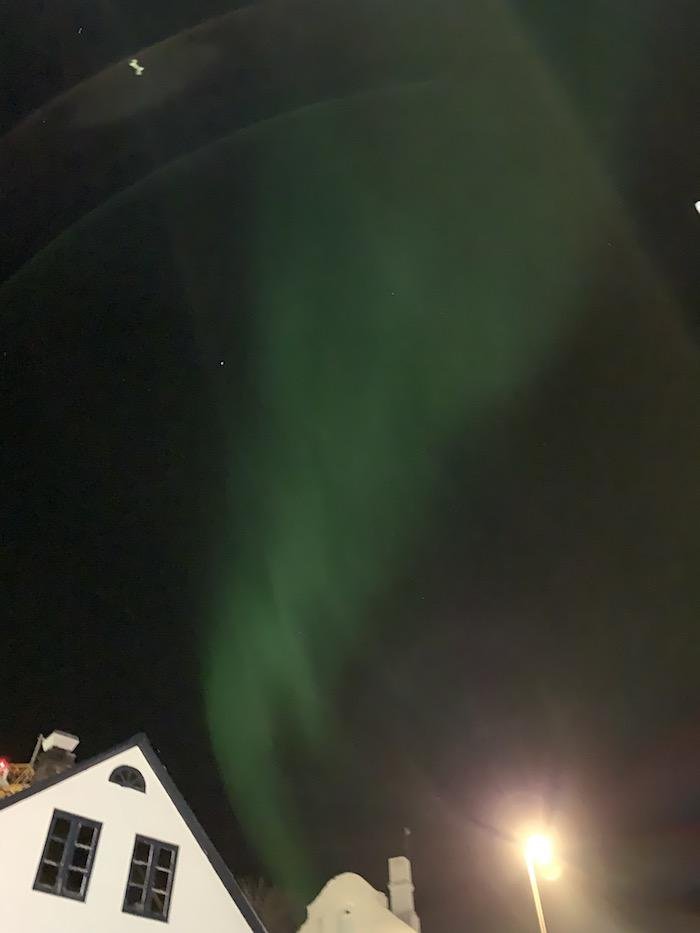 the northern lights above Reykjavik houses