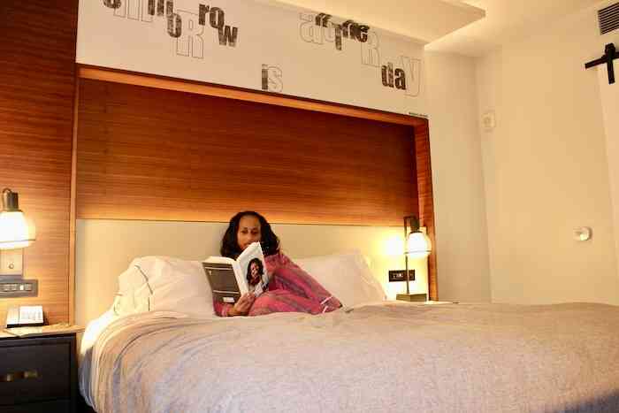 Nadeen reading in bed at the Canopy Hotel Atlanta